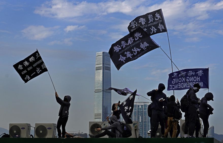Protesters wave flags that read "Hong Kong Independence" during a rally in Hong Kong, Sunday, Jan. 12, 2020. More than a thousand people attended a Sunday rally in Hong Kong to urge people and governments abroad to support the territory's pro-democracy movement and oppose China's ruling Communist Party. (AP Photo/Vincent Yu)