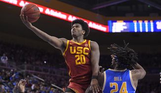 Southern California guard Ethan Anderson, left, shoots as UCLA forward Jalen Hill defends during the first half of an NCAA college basketball game Saturday, Jan. 11, 2020, in Los Angeles. (AP Photo/Mark J. Terrill)