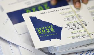 In this Aug. 13, 2019, file photo a worker gets ready to pass out instructions on how to fill out the 2020 census during a town hall meeting in Lithonia, Ga.  (AP Photo/John Amis, File) **FILE**