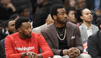 Washington Wizards guard John Wall, right, watches from the bench next to guard Jordan McRae, left, during the first half of an NBA basketball game, Sunday, Jan. 12, 2020, in Washington. (AP Photo/Nick Wass) ** FILE **
