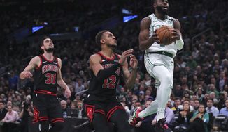 Boston Celtics guard Jaylen Brown (7) outruns Chicago Bulls guard Tomas Satoransky (31) and forward Daniel Gafford (12) on a drive to the basket during the first half of an NBA basketball game in Boston, Monday, Jan. 13, 2020. (AP Photo/Charles Krupa)
