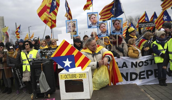 Demonstrators hold signs showing Catalan politician Oriol Junqueras as they protest outside the European Parliament in Strasbourg, eastern France, Monday, Jan. 13, 2020. Catalan leader Carles Puigdemont is expected to attend his first session as a member of the European Parliament on Monday despite facing an arrest warrant against him in Spain. (AP Photo/Francisco Seco)