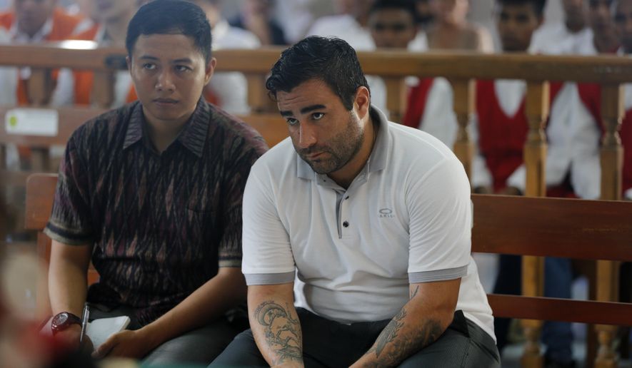 Ian Andrew Hernandez of California, right, sits in a courtroom during his verdict trial in Bali, Indonesia on Monday, Jan. 13, 2020. An Indonesian judge has sentenced Hernandes to nine years and four months into prison for possessing and circulating 5 grams of cocaine and marijuana. (AP Photo/Firdia Lisnawati)