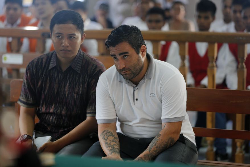 Ian Andrew Hernandez of California, right, sits in a courtroom during his verdict trial in Bali, Indonesia on Monday, Jan. 13, 2020. An Indonesian judge has sentenced Hernandes to nine years and four months into prison for possessing and circulating 5 grams of cocaine and marijuana. (AP Photo/Firdia Lisnawati)