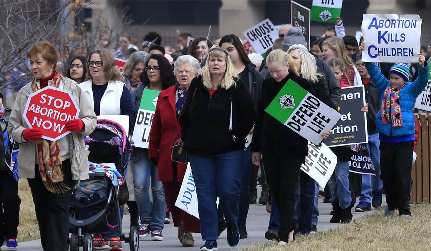 FILE - In this Jan. 23, 2017, file photo, marchers arrive for a Roe v. Wade protest as hundreds converge on the Kansas Statehouse in Topika, Kan. Top Kansas Republicans are pushing to overturn a state Supreme Court decision that protects abortion rights but say they can't get enough support to ban abortion.The Legislature expects to consider a proposed amendment to the Kansas Constitution during the annual 90-day lawmaking session set to convene Monday, Jan. 13, 2020. It's a response to the state high court's ruling in April that the state's Bill of Rights makes access to abortion a fundamental right. (AP Photo/Orlin Wagner, File)