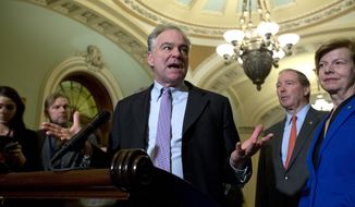 Sen. Tim Kaine D-Va., accompanied by Sen. Tammy Baldwin, D-Wis., and other senators, speaks during a news conference outside of the Senate chamber, on Capitol Hill in Washington, Tuesday, Jan. 14, 2020. (AP Photo/Jose Luis Magana)