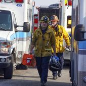Firefighter/paramedics walk between a group of ambulances parked by Park Avenue Elementary School after jet fuel was dumped on the school in Cudahy, Calif., Tuesday, Jan. 14, 2020. A pair of people, one a homeless man, were found dead in a man-dug cave Sunday in Northridge, near Los Angeles. White powder containing fentanyl was also found. (Scott Varley/The Orange County Register via AP)