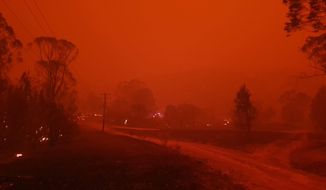 In this Dec. 31, 2019, photo provided by Siobhan Threlfall, fire and thick smoke remains the village of Nerrigundah, Australia. The tiny village has been among the hardest hit by Australia&#39;s devastating wildfires, with about two thirds of the homes destroyed and a 71-year-old man killed. (AP Photo/Siobhan Threlfall)
