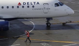 FIE - In this Feb. 5, 2019, file photo a ramp worker guides a Delta Air Lines plane at Seattle-Tacoma International Airport in Seattle. Delta Air Lines says it earned $1.1 billion in the fourth quarter by operating more flights and filling a higher percentage of seats.  The financial results beat Wall Street expectations. Delta and other U.S. airlines are enjoying a prolonged period of profitability thanks to steadily rising demand for travel.   (AP Photo/Ted S. Warren, File)