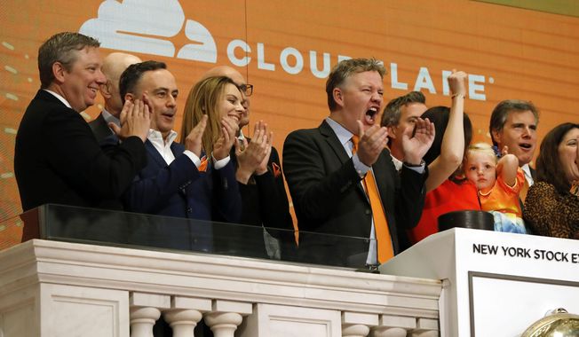 FILE - In this Sept. 13, 2019, file photo, Cloudflare co-founder and CEO Matthew Prince, right center, applauds during New York Stock Exchange opening bell ceremonies to celebrate his company&#x27;s IPO. San Francisco-based Cloudflare said Wednesday, Jan. 15, 2020, it will provide free cybersecurity support to federal election campaigns. (AP Photo/Richard Drew, File)