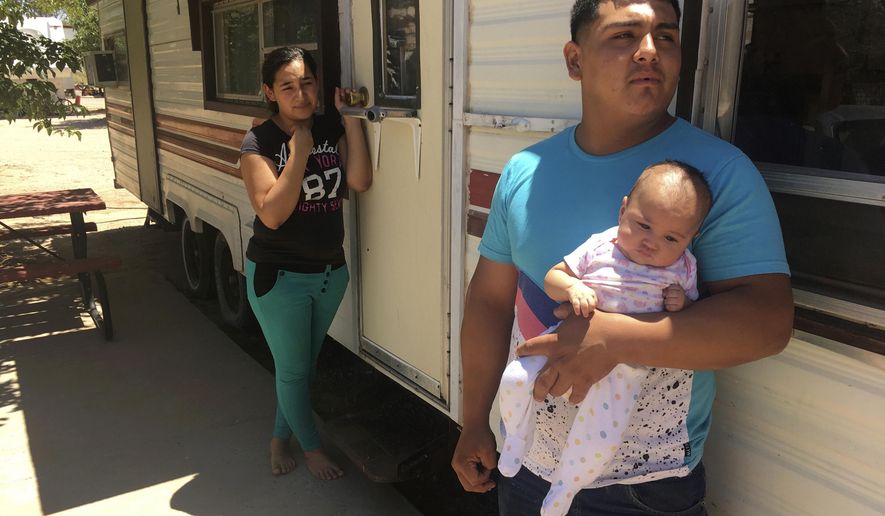 FILE - In this May 25, 2018, file photo, Jose Espinoza, 18, stands outside his trailer with his 4-month-old infant, Emmily, and wife, Maria Rodriguez, 19, in Vado, N.M. while speaking about making only $50 a day picking onions. New Mexico&#39;s child poverty rate rose slightly and continues to rank near the bottom nationally despite improvements in the state&#39;s economy, a child-advocacy group said Wednesday, Jan. 15, 2020. The 2019 New Mexico Kids Count Data Book, released by New Mexico Voices for Children, found 26% of the state&#39;s children in 2018 remained at or below the federal poverty line. That places the state back to 49th nationally in child poverty. (AP Photo/Russell Contreras, File)
