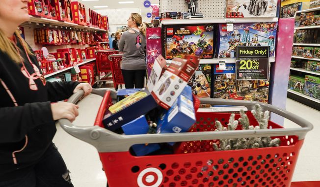 FILE- In this Nov. 23, 2018, file photo shoppers browse the aisles during a Black Friday sale at a Target store in Newport, Ky. Comparable stores sales at Target fell well below the previous year, joining a growing list of retailers reporting a meager performances during the critical holiday shopping season. Target said Wednesday, Jan. 15, 2020, that it had weaker-than-expected sales of electronics, toys and some home good. Those sales climbed 1.4% in the November-December period, compared with a 5.7% increase a year earlier.  (AP Photo/John Minchillo, File)
