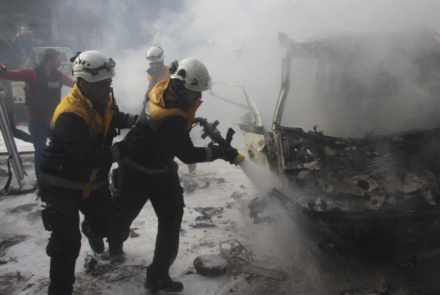 This photo provided by the Syrian Civil Defense White Helmets, which has been authenticated based on its contents and other AP reporting, shows Syrian White Helmet civil defense workers extinguish a burning car that was hit by Syrian government airstrikes, in Idlib province, Syria, Wednesday, Jan. 15, 2020. Syrian government warplanes struck a market and an industrial area on Wednesday in the last territory in the hands of rebel groups in the country's northwest, killing at least 15 people, opposition activists said. (Syrian Civil Defense White Helmets via AP)