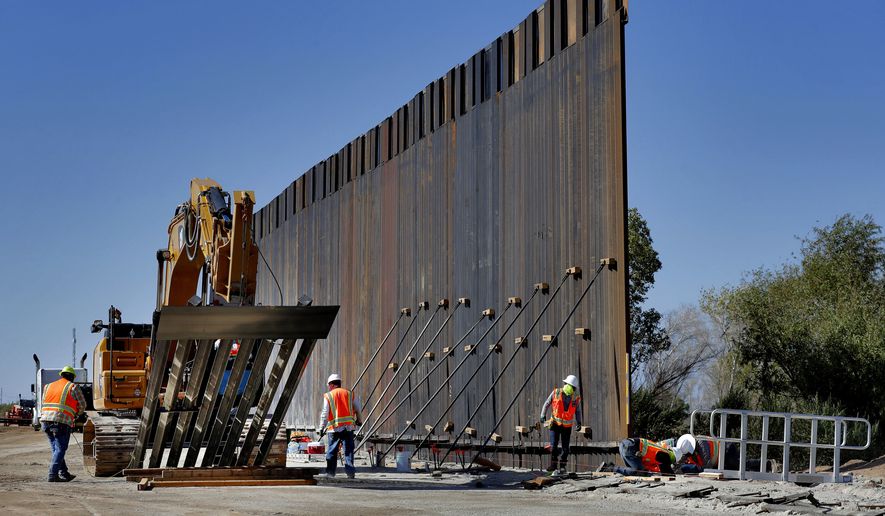 In this Sept. 10, 2019, file photo, government contractors erect a section of Pentagon-funded border wall along the Colorado River in Yuma, Ariz. (AP Photo/Matt York) ** FILE **