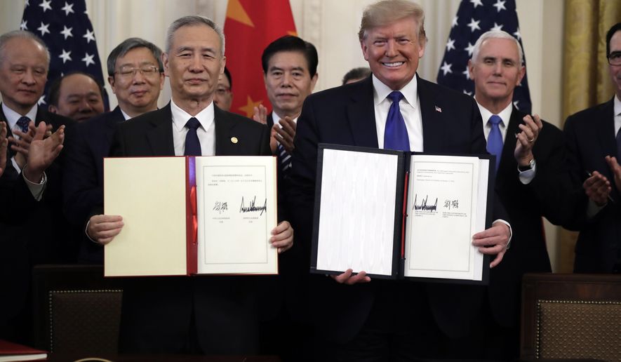 FILE - In this Wednesday, Jan. 15, 2020, file photo, U.S. President Donald Trump, right, signs a trade agreement with Chinese Vice Premier Liu He, in the East Room of the White House, in Washington. China’s government welcomed an interim trade deal with Washington and said Thursday the two sides need to address each other’s “core concerns.” (AP Photo/Evan Vucci, File)