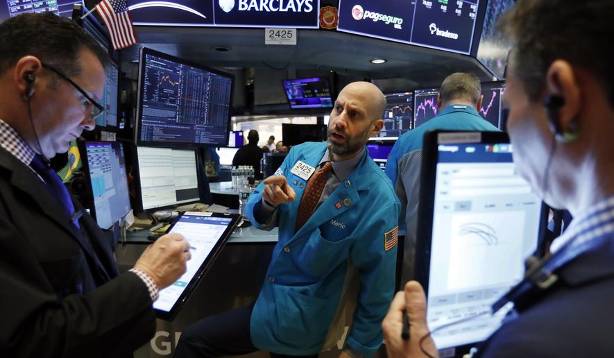 FILE - In this Jan. 10, 2020, file photo specialist Meric Greenbaum, center, works at his post on the floor of the New York Stock Exchange. The U.S. stock market opens at 9:30 a.m. EST on Thursday, Jan. 16. (AP Photo/Richard Drew, File)