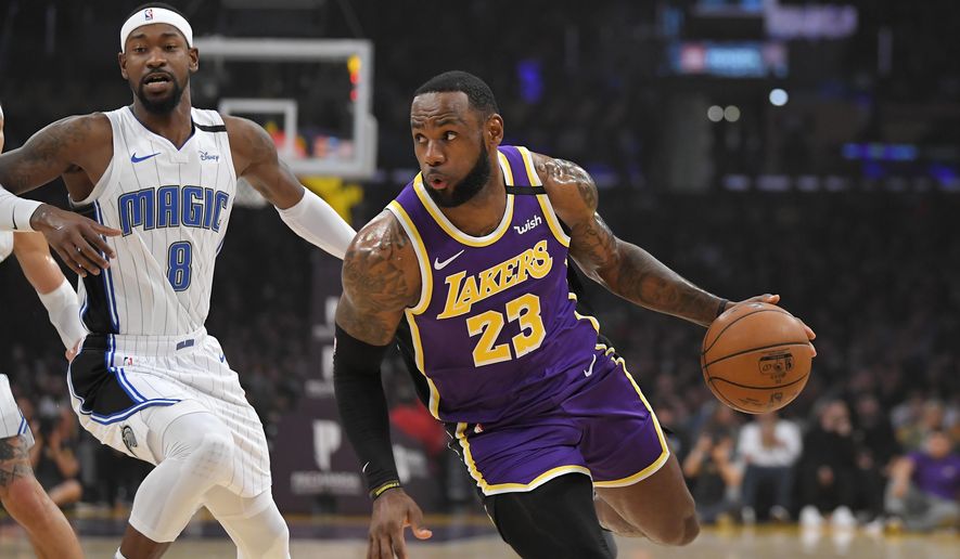 Los Angeles Lakers forward LeBron James, right, drives toward the basket as Orlando Magic guard Terrence Ross defends during the first half of an NBA basketball game Wednesday, Jan. 15, 2020, in Los Angeles. (AP Photo/Mark J. Terrill)