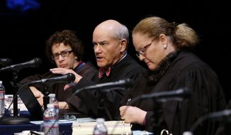 FILE - In this Nov. 15, 2016, file photo Washington Supreme Court Justice Charles K. Wiggins, second left, speaks as fellow Justices Sheryl Gordon McCloud, left, and Mary E. Fairhurst listen during arguments in Bellevue, Wash. Wiggins, 72, announced Thursday, Jan. 16, 2020, he will retire at the end of March. Wiggins was first elected to the court in 2010. (AP Photo/Elaine Thompson, File)