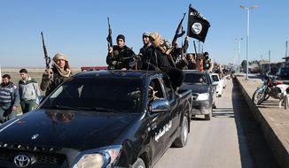 In this this file photo released on May 4, 2015, on a militant website, which has been verified and is consistent with other AP reporting, Islamic State militants pass by a convoy in Tel Abyad, northeast Syria.   The Washington-based Syria Justice and Accountability Center, a U.S.-based Syrian rights group, said Thursday, Jan. 16, 2020,  that evidence, documents produced by the Islamic State militants themselves,  could help identify individuals responsible for atrocities during the militants four-year reign of terror in Syria, thus enabling prosecution for international crimes. (Militant website via AP, File)