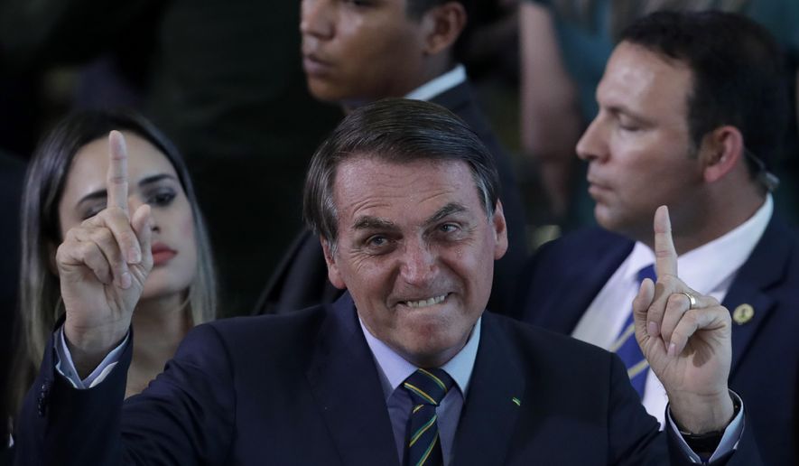 Brazil&#39;s President Jair Bolsonaro gestures during an event with young Venezuelan migrants at the Planalto Presidential Palace in Brasilia, Brazil, Thursday, Jan. 16, 2020. According to the UNHCR there are around 180,000 Venezuelan refugees and migrants in the country, many of them arrived crossing the border  in the northern state of Roraima. (AP Photo/Eraldo Peres)