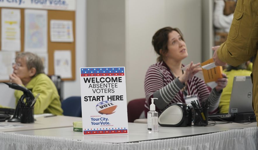 A poll worker speaks with a voter as Minneapolis Early Voting Center opened, Friday, Jan. 17, 2020, in Minneapolis. (Glen Stubbe/Star Tribune via AP)