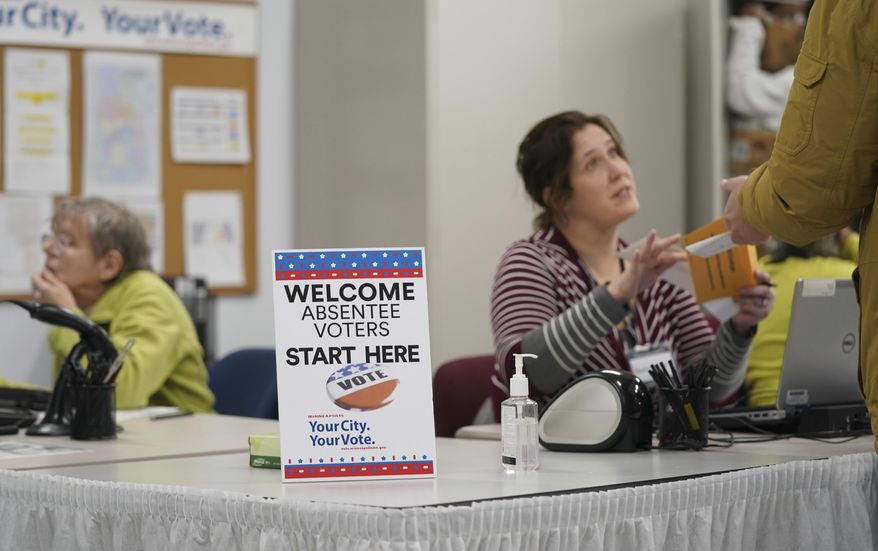 A poll worker speaks with a voter as Minneapolis Early Voting Center opened, Friday, Jan. 17, 2020, in Minneapolis. (Glen Stubbe/Star Tribune via AP)