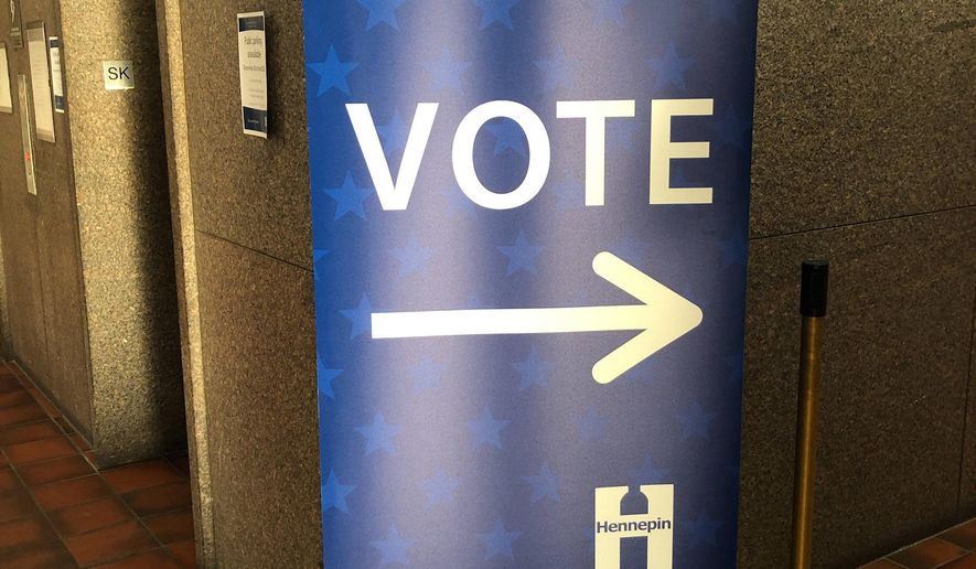In this Jan. 9, 2020 photo, a sign points the way to the early voting station that has already been set up at the Hennepin County Government Center in downtown Minneapolis in preparation for the start of early voting on Friday, Jan. 17, in Minnesota's March 3 presidential primary. (AP Photo/Steve Karnowski)