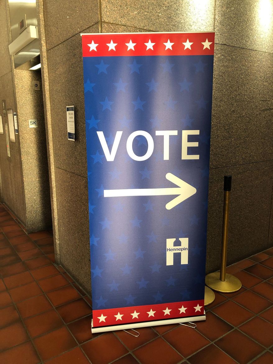 In this Jan. 9, 2020 photo, a sign points the way to the early voting station that has already been set up at the Hennepin County Government Center in downtown Minneapolis in preparation for the start of early voting on Friday, Jan. 17, in Minnesota's March 3 presidential primary. (AP Photo/Steve Karnowski)
