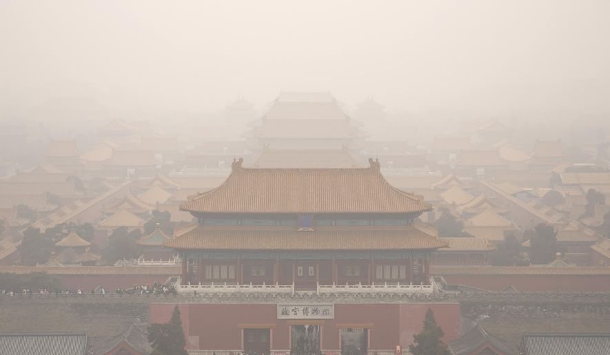 Tourists exit the Forbidden City in Beijing, Saturday, Jan. 18, 2020. A Chinese woman sparked social media outrage in her country by posting photos of herself and a friend with a Mercedes-Benz SUV on the grounds of Beijing's landmark Forbidden City, prompting an apology from the management of China's former imperial palace. (AP Photo/Mark Schiefelbein)