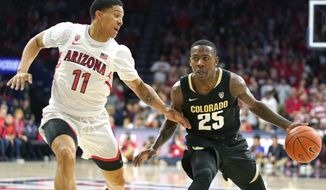 Colorado guard McKinley Wright IV (25) shields the ball from Arizona forward Ira Lee during the first half of an NCAA college basketball game Saturday, Jan. 18, 2020, in Tucson, Ariz. (AP Photo/Rick Scuteri)