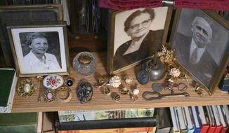 In this Wednesday, Jan. 8. 2020 photo, jewelry is positioned next to old family photos as family heirloom jewelry comprise a portion of Michael Cruz&#39;s antique collection at his home in Westminster, Md. (Brian Krista/The Baltimore Sun via AP)