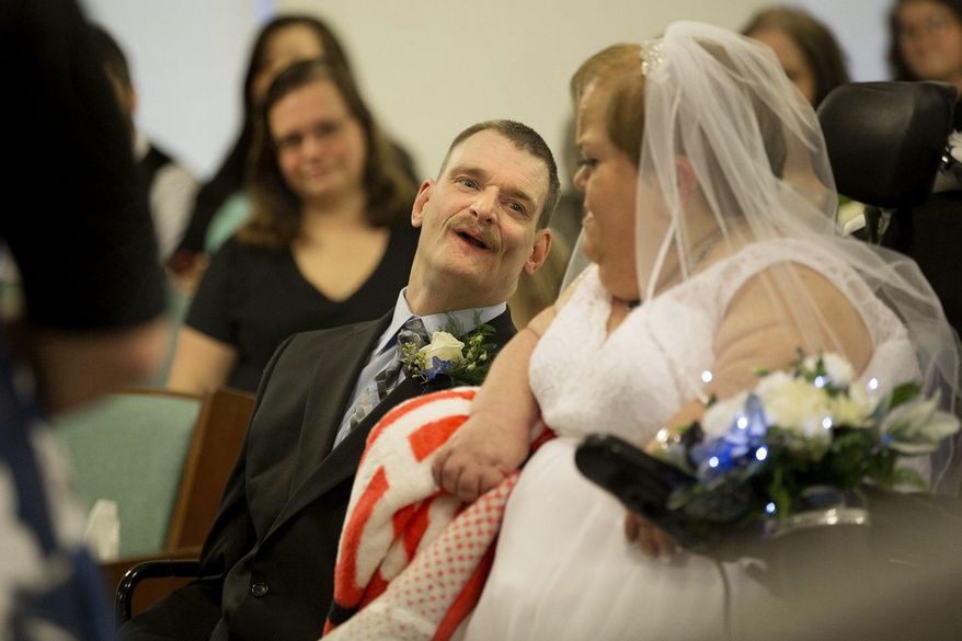 In this Saturday, Jan. 4, 2020, photo, Bill Adams and Sherri Daniel exchange vows at Christ Restoration Branch church, in Lucasville, Scioto County, Ohio. After a years-long fight for their right to marry without losing any of their disability income, the couple finally wed this month. The couple found out Sherri can keep her income as a dependent drawing from her deceased father's Social Security. (Courtney Hergesheimer/The Columbus Dispatch via AP)