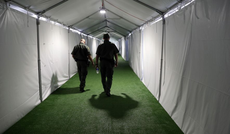 FILE - In this May 2, 2019, file photo, U.S. Border Patrol agents walk down the hallway of a new U.S. Customs and Border Protection temporary facility near the Donna International Bridge in Donna, Texas. The U.S. government says it will deport a Honduran mother and her two sick children, both of whom are currently hospitalized, to Guatemala as soon as it can get them medically cleared to travel, according to court documents and the family’s advocates. (AP Photo/Eric Gay, File)