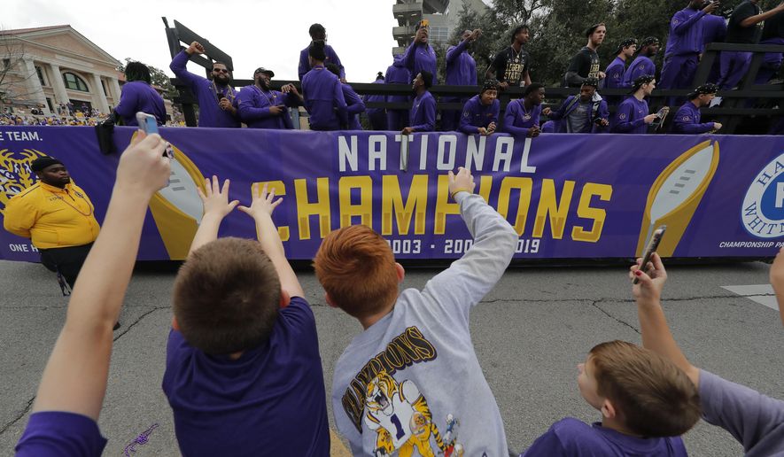 LSU fans cheer as players ride on floats during a parade celebrating LSU's NCAA college football championship, Saturday, Jan. 18, 2020, on the LSU campus in Baton Rouge, La. (AP Photo/Gerald Herbert)