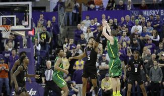 Oregon guard Payton Pritchard, right, shoots the game-winning 3-point basket as Washington guard Jamal Bey (5) tries for the block during overtime in an NCAA college basketball game, Saturday, Jan. 18, 2020, in Seattle. Oregon won 64-61 in overtime. (AP Photo/Ted S. Warren)