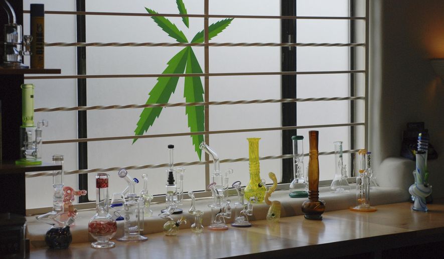 FILE - In this June 11,l 2019 file photo Marijuana equipment lines along a window at the Minerva medical cannabis dispensary in Santa Fe, N.M. New Mexico would legalize recreational marijuana sales without exceptions for dissenting cities and counties under a rebooted proposal form legislators that emphasizes small business opportunities and ready access to pot for 80,000 current medical cannabis patients. Legalization for the first time enjoys the full throttled support of second-year Democratic Gov. Michelle Lujan Grisham, who set up a volunteer commission last year to vet health and public safety concerns about recreational cannabis and on Thursday, Jan. 16, 2020, pitched the benefits of the pot economy to a gathering business leaders. (AP Photo/Morgan Lee)