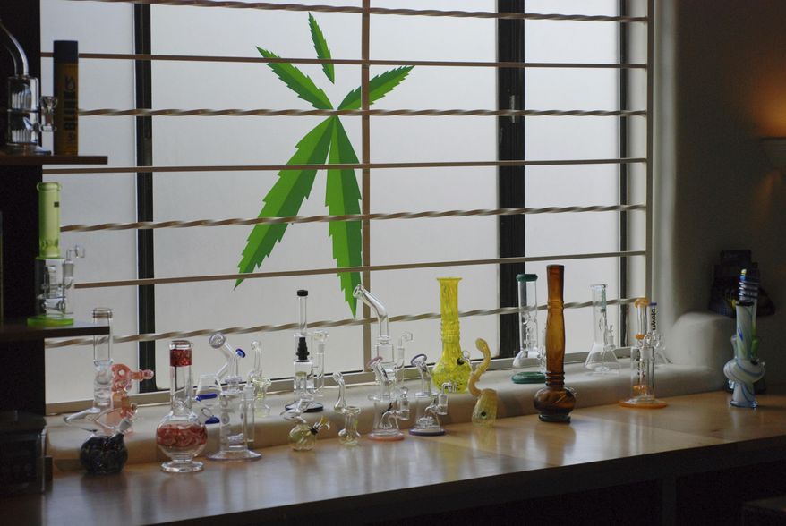FILE - In this June 11,l 2019 file photo Marijuana equipment lines along a window at the Minerva medical cannabis dispensary in Santa Fe, N.M. New Mexico would legalize recreational marijuana sales without exceptions for dissenting cities and counties under a rebooted proposal form legislators that emphasizes small business opportunities and ready access to pot for 80,000 current medical cannabis patients. Legalization for the first time enjoys the full throttled support of second-year Democratic Gov. Michelle Lujan Grisham, who set up a volunteer commission last year to vet health and public safety concerns about recreational cannabis and on Thursday, Jan. 16, 2020, pitched the benefits of the pot economy to a gathering business leaders. (AP Photo/Morgan Lee)