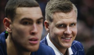 Dallas Mavericks forwards Kristaps Porzingis, right, and Dwight Powell watch from the bench during the first half of the team&#39;s NBA basketball game against the Portland Trail Blazers, Friday, Jan. 17, 2020, in Dallas. (AP Photo/Brandon Wade)