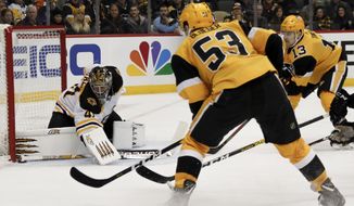 Boston Bruins goaltender Jaroslav Halak (41) keeps the puck out of the net as Pittsburgh Penguins&#x27; Teddy Blueger (53) and Brandon Tanev (13) look for a rebound during the second period of an NHL hockey game, Sunday, Jan. 19, 2020, in Pittsburgh. (AP Photo/Keith Srakocic)