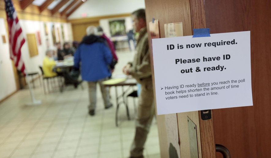 FILE - In this Feb. 16, 2016, file photo, a sign informs voters of the need for identification at the Olbrich Gardens polling location in Madison, Wis. Democrats are hoping this is the year they can finally make political headway in Texas and have set their sights on trying to win a majority in one house of the state legislature. Among the big hurdles they’ll have to overcome are a series of voting restrictions Texas Republicans have implemented in recent years, including the nation’s toughest voter ID law, purging of voter rolls and reductions in polling places. (Michael P. King/Wisconsin State Journal via AP, File)