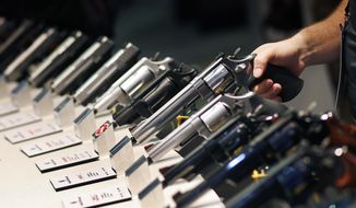 In this Jan. 19, 2016, file photo, handguns are displayed at the Smith &amp;amp; Wesson booth at the Shooting, Hunting and Outdoor Trade Show in Las Vegas. (AP Photo/John Locher, File) ** FILE **