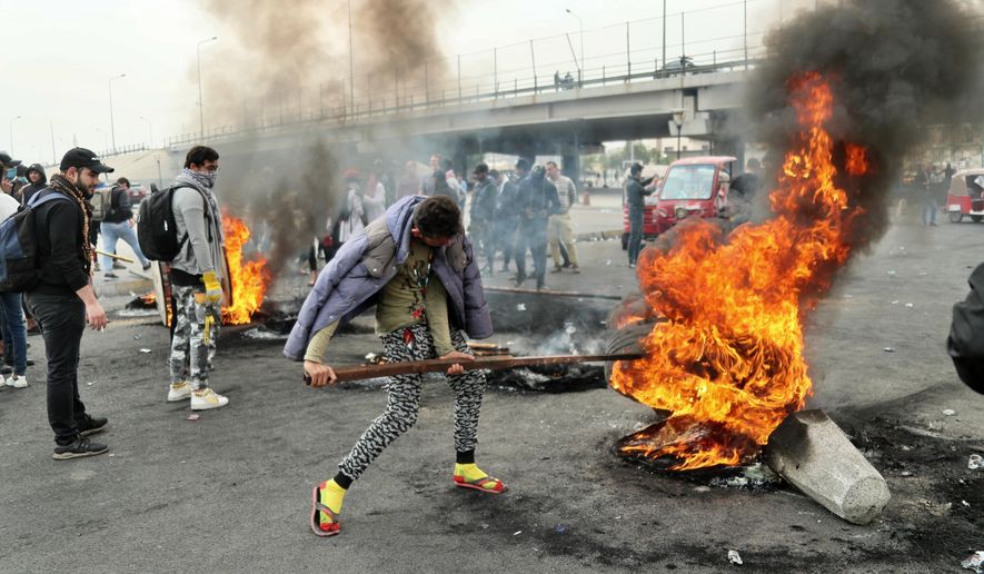 Anti-government protesters set fires and close streets during ongoing protests in downtown Baghdad, Iraq, Sunday, Jan. 19, 2020. Black smoke filled the air as protesters burned tires to block main roads in the Iraqi capital Baghdad, expressing their anger at poor services and shortages despite religious and political leaders calling for calm. (AP Photo/Hadi Mizban)