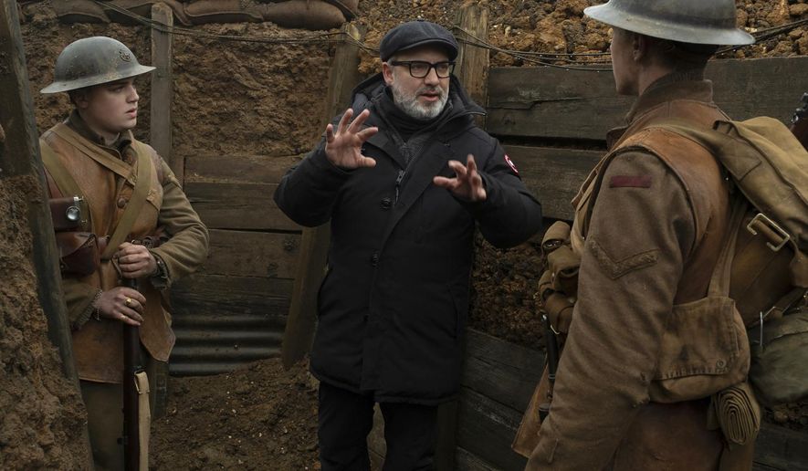 This image released by Universal Pictures shows Dean-Charles Chapman, left, director Sam Mendes, center, and George MacKay on the set of "1917." On Monday, Jan. 13, Mendes was nominated for an Oscar for best director for his work on the film. (François Duhamel/Universal Pictures via AP)