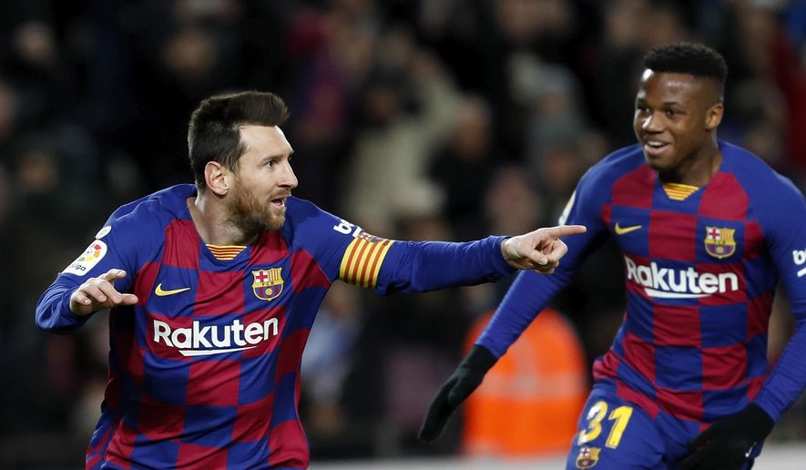 Barcelona&#x27;s Lionel Messi, left, celebrates with Ansu Fati after scoring the opening goal during a Spanish La Liga soccer match between Barcelona and Granada at Camp Nou stadium in Barcelona, Spain, Sunday, Jan. 19, 2020. (AP Photo/Joan Monfort)
