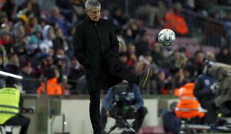 Barcelona&#39;s head coach Quique Setien kicks the ball back to the pitch during a Spanish La Liga soccer match between Barcelona and Granada at Camp Nou stadium in Barcelona, Spain, Sunday, Jan. 19, 2020. (AP Photo/Joan Monfort)