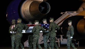 A U.S. Marine Corps carry team moves a transfer case containing the remains of Staff Sgt. Christopher Slutman, Thursday, April 11, 2019, at Dover Air Force Base, Del. According to the Department of Defense, Slutman, of Newark, Del., was among three American service members killed by a roadside bomb on Monday, April 8, near Bagram Airfield in Afghanistan. (AP Photo/Patrick Semansky)