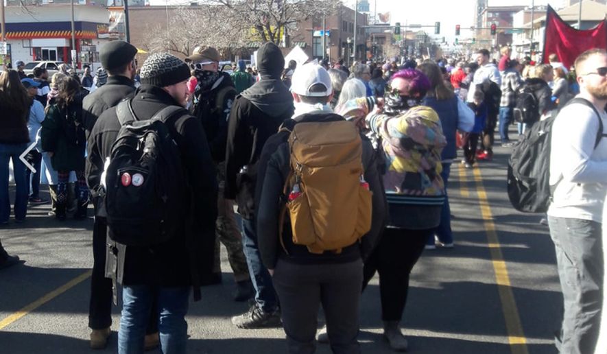 Eight to 10 masked antifa activists — all of them white — shadowed the marchers, walking in step with them for the entirety of the 3.1-mile route, and eventually drawing a police escort. (Photo by Derrick Wilburn via Rocky Mountain Black Conservatives)