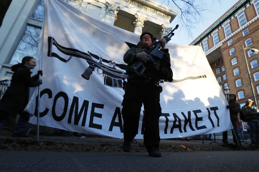 Demonstrators stand outside a security zone before a pro gun rally, Monday, Jan. 20, 2020, in Richmond, Va. Thousands of pro-gun supporters are expected at the rally to oppose gun control legislation like universal background checks that are being pushed by the newly elected Democratic legislature. (AP Photo/Julio Cortez)