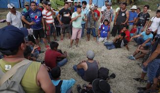 Honduran migrants gather at a temporary shelter in Tecun Uman, Guatemala, on the border with Mexico, Sunday, Jan. 19, 2020. More than 2,000 migrants spent the night in Tecun Uman on the Guatemalan side of the border, uncertain of their next steps. (AP Photo/Moises Castillo)