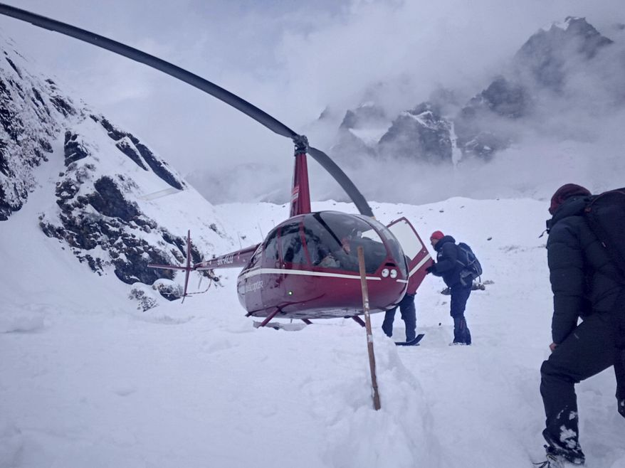 In this Saturday, Jan. 18, 2020 photo, trekkers are being rescued in an helicopter a day after after an avalanche hit Mount Annapurna trail in Nepal. Special army and government rescue personnel were searching again on Monday for four South Korean trekkers and their three Nepali guides lost since an avalanche swept a popular trekking route in Nepal&#39;s mountains. (AP Photo/Phurba Ongel Sherpa)